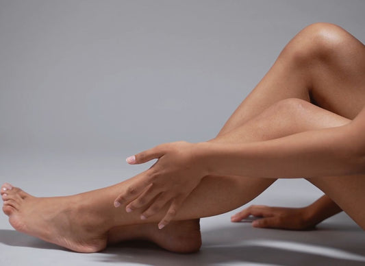 devojka dodiruje rukama svoje noge koje su sveže izdepilirane