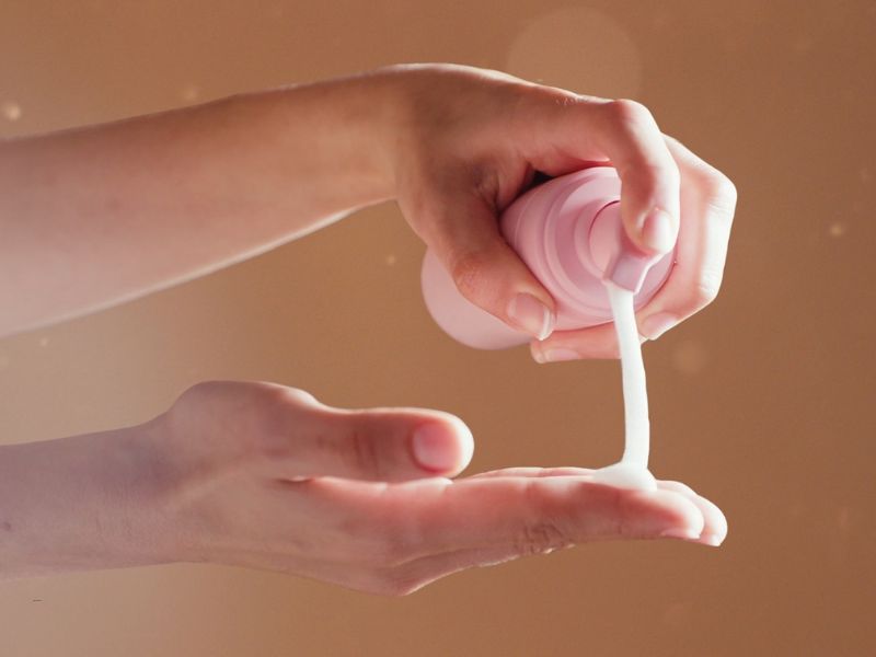 osoba sipa penu za intimnu regiju na dlan, svetlo smeđa pozadina